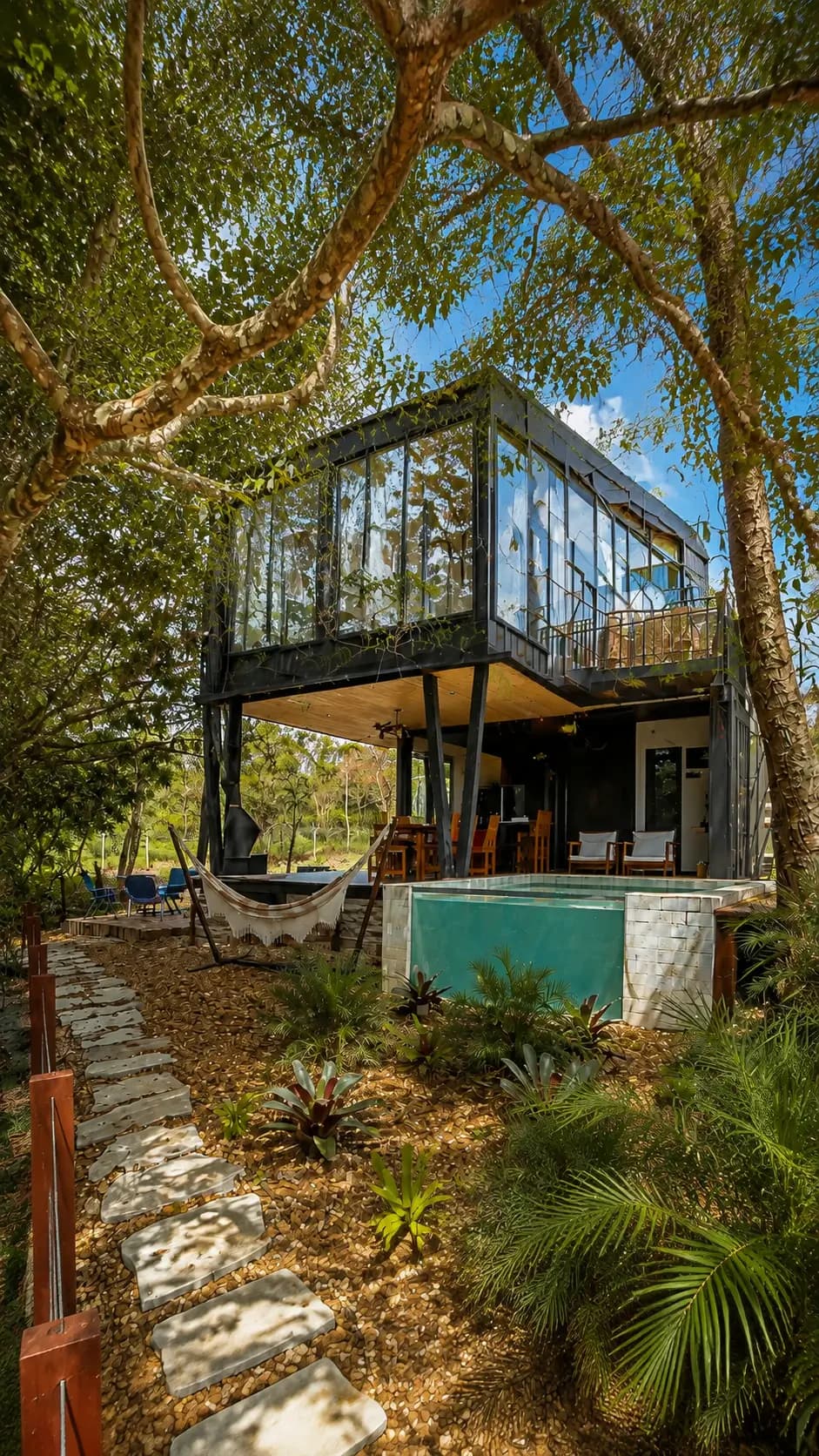 Chalé de arquitetura contemporânea com piscina privativa ao entardecer, em meio ao cerrado